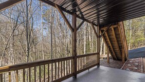 A covered outdoor area with a wooden deck and metal roof, surrounded by trees. - Crooked Lane Cabin - Murphy (Murphy)