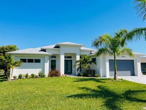 A modern two-story house with a flat roof, a garage, and a well-maintained lawn. - Villa Elements - new, on water, pool, spa, modern (Cape Coral)
