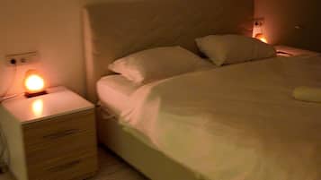 Un dormitorio con cama, mesita de noche y velador.