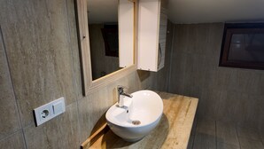 A modern bathroom with a white sink, a mirror, and a wooden countertop. - KARYA OTEL (Çandır)