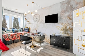Une chambre à coucher moderne avec un lit, une table de chevet et un téléviseur fixé au mur.