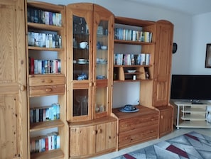 Une pièce construite en bois, dotée d’étagères intégrées, d’un téléviseur et d’un tapis à motifs.