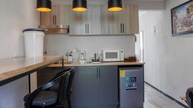 A modern kitchen with a central island, black pendant lights, and a refrigerator with a digital display. - *comfortable loft in the center of Quetzaltenango (Quetzaltenango)
