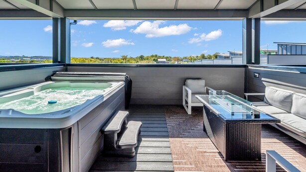 Une terrasse sur le toit dotée d’un jacuzzi, d’un espace salon et offrant une vue sur le paysage.