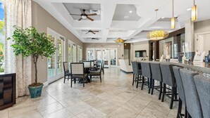 A modern hotel lobby with a reception desk, bar area, and seating. - 5BR Home with Pool & Resort Amenities Near Disney (Davenport)