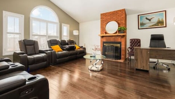 A living room with a fireplace, a sofa, a recliner, and a desk. - Maple Nest Pickering for your stay (Pickering)