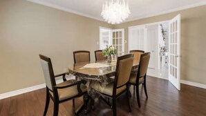 A dining room with a round table, six chairs, and a chandelier. - Maple Nest Pickering for your stay (Pickering)