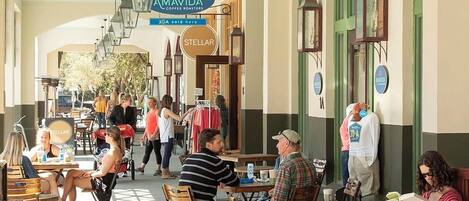 Ett utomhuskafé med bord och stolar, en skylt med texten ”AMAVIDA Coffee Roasters” och en skylt som visar betyget ”STELLAR”.