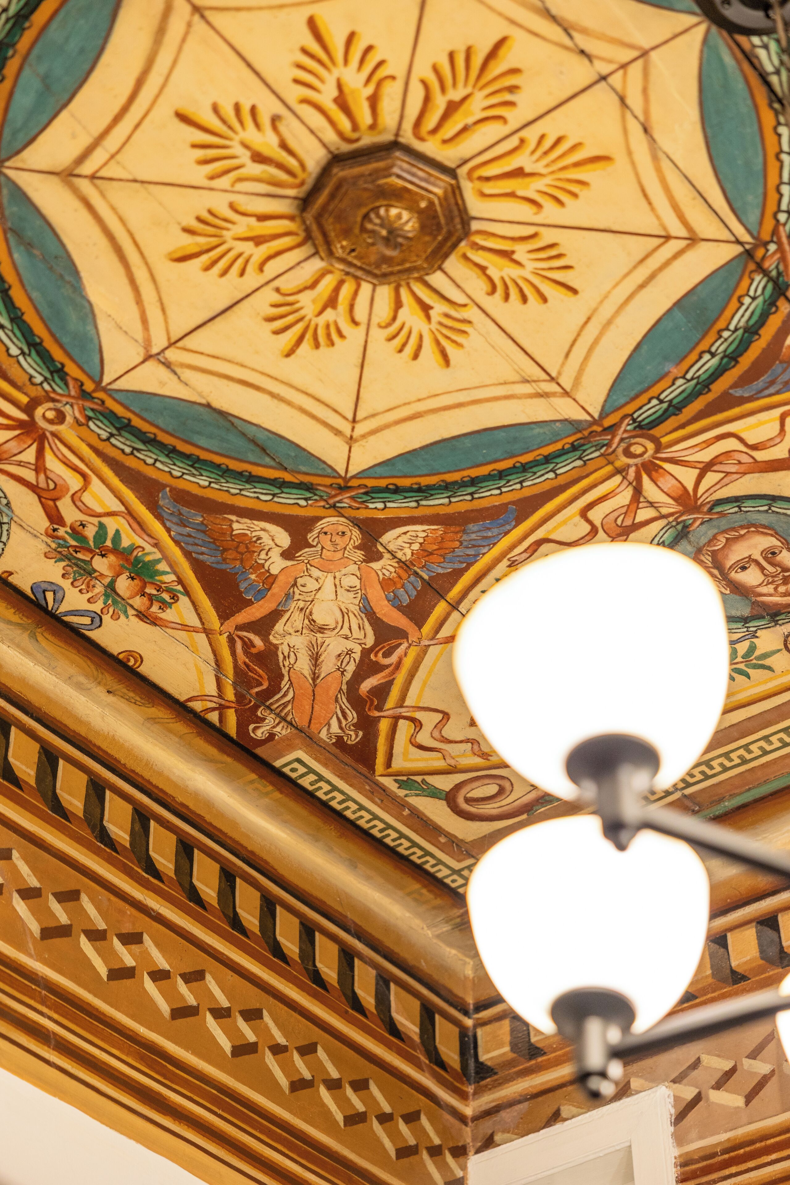 A ceiling with a geometric pattern and a central hexagonal design.