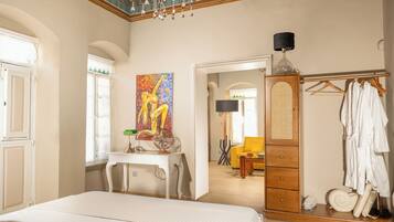 Un dormitorio con cama, escritorio, cuadro, armario y espejo.