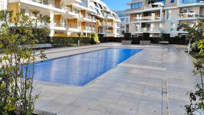 A modern apartment complex with a swimming pool, balconies, and a well-maintained garden. - Luxury Apartment With Pool & Parking (Nieuwpoort)