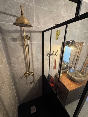 Ein Badezimmer mit Dusche, Waschbecken und Spiegel.