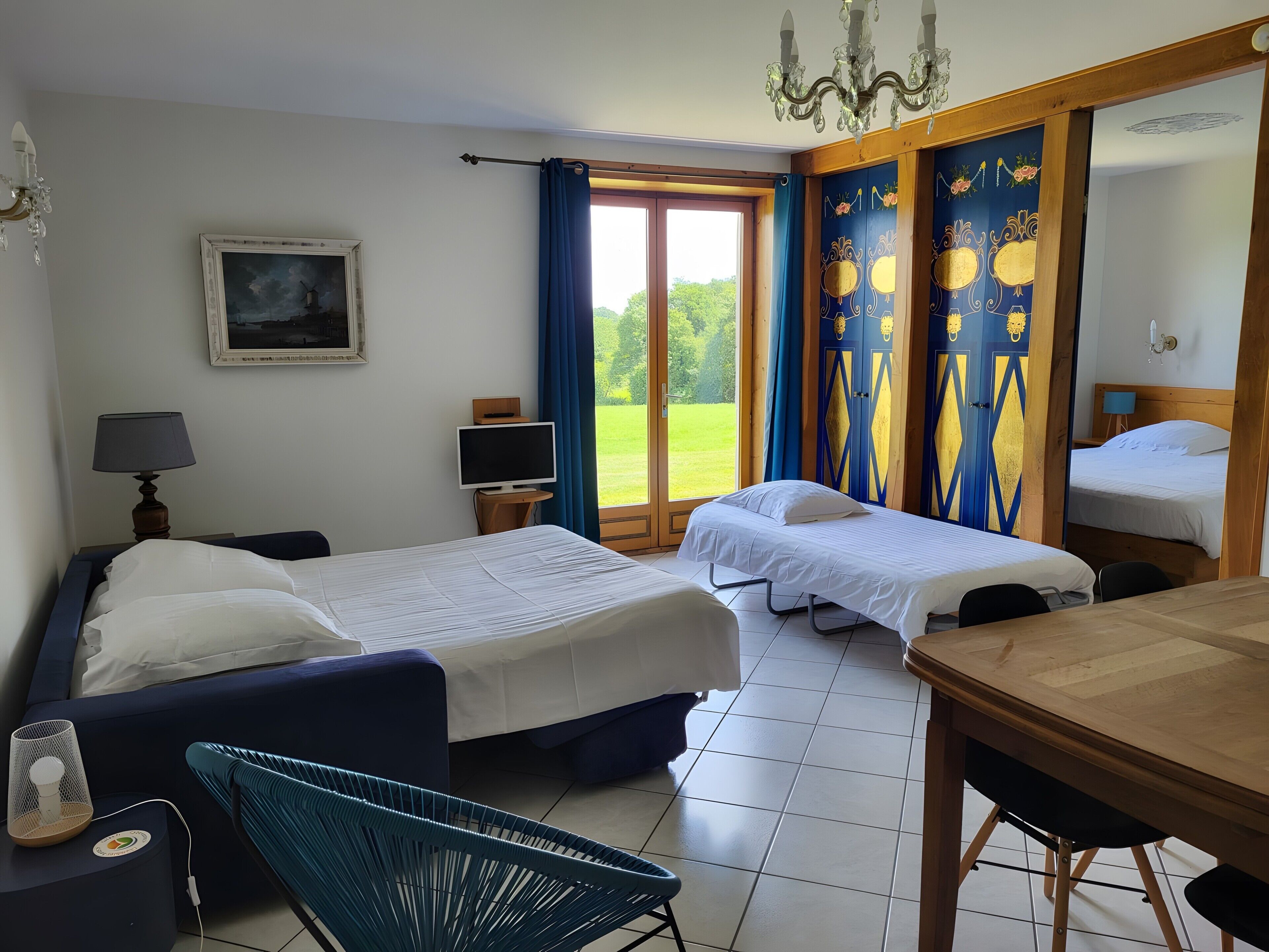 Ein Hotelzimmer mit einem Bett, einem Schreibtisch, einem Stuhl, einem Fernseher und einem Fenster mit Vorhängen.