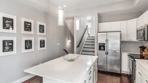 A modern kitchen with white cabinetry, stainless steel appliances, and a central island. - Skyline Haven #1–Nashville Views–Sleeps 6 (Nashville)
