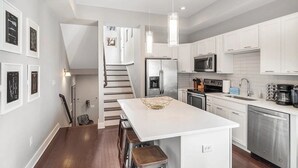 A modern kitchen with white cabinets, stainless steel appliances, and a central island. - Skyline Haven #1–Nashville Views–Sleeps 6 (Nashville)
