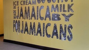Eine Wand mit Werbung für vegane Kokoseis, hergestellt in Jamaika.