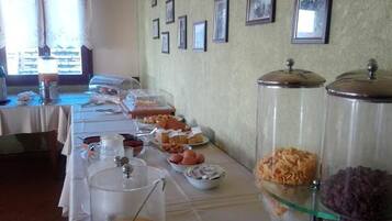 Un buffet proposant une variété de plats et un mur décoré de tableaux encadrés.