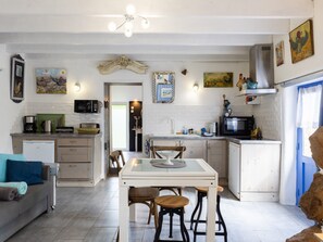 Une cuisine compacte comprenant un coin repas, un réfrigérateur, un four à micro-ondes et un évier.