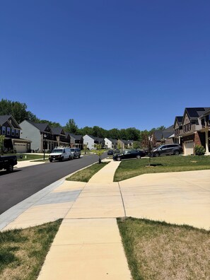 A suburban street with houses, parked cars, and a sidewalk. - Serene 1-bedroom basement in welcoming Upper Marlboro perfect for getaway (Upper Marlboro)