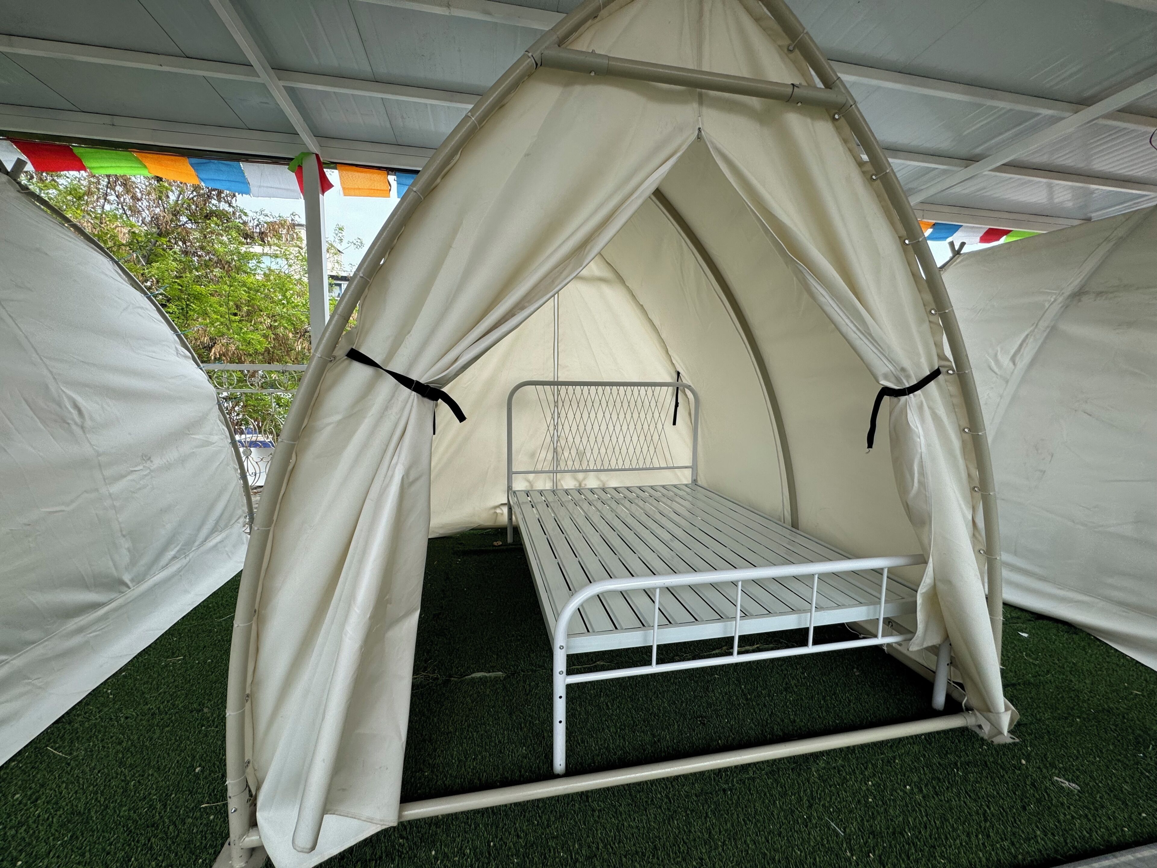 A tent with a metal bed frame and a canopy.