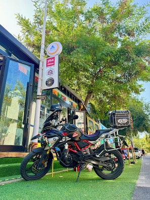 A motorcycle parked in front of a building with a sign indicating a restaurant. - Kailash International Youth Hostel-SixStarStreetFlagship (Yining)