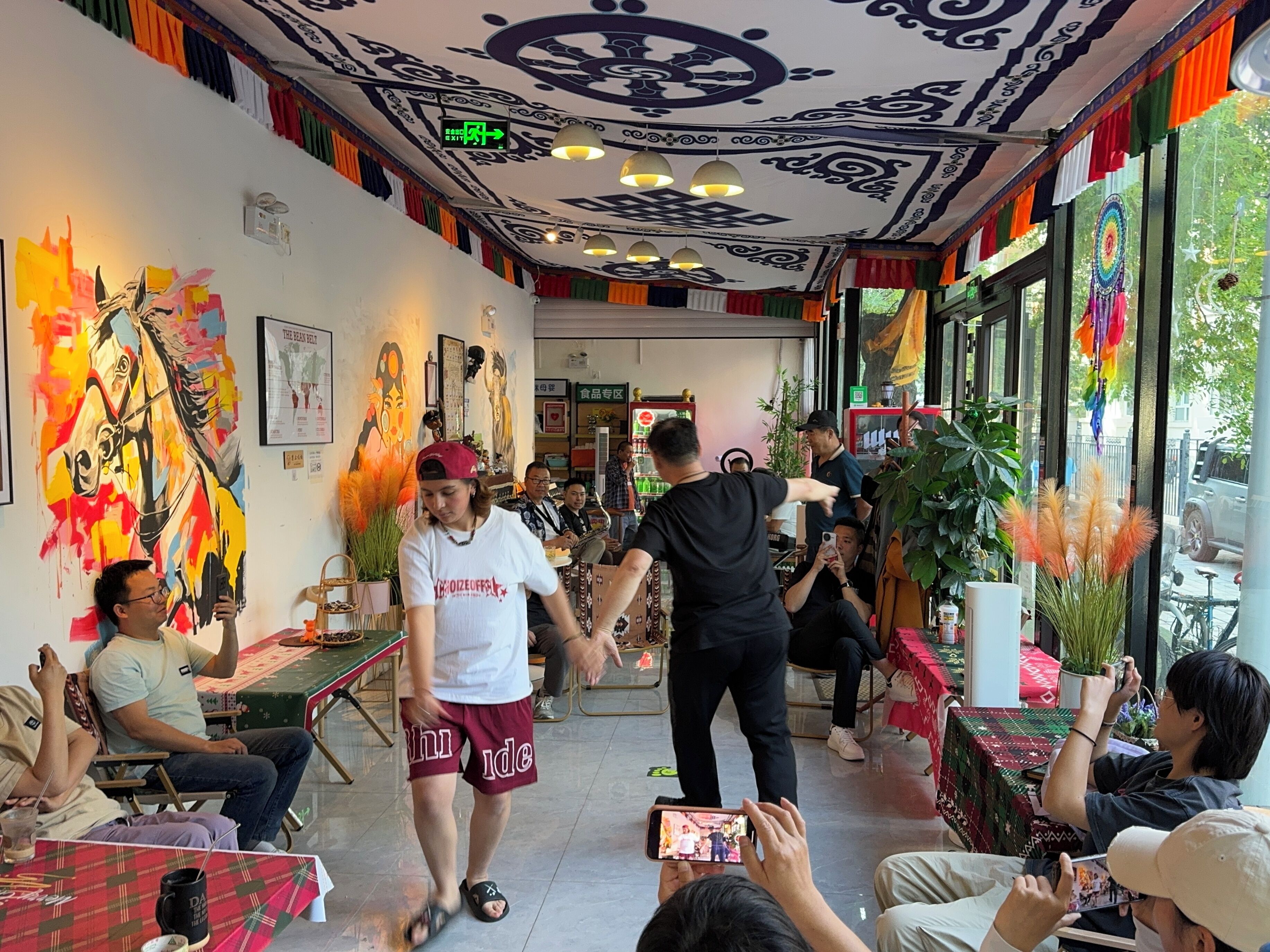 A vibrant interior with a central walkway, colorful wall art, and a ceiling with intricate patterns.
