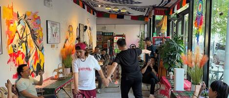 A vibrant interior with a central walkway, colorful wall art, and a ceiling with intricate patterns.