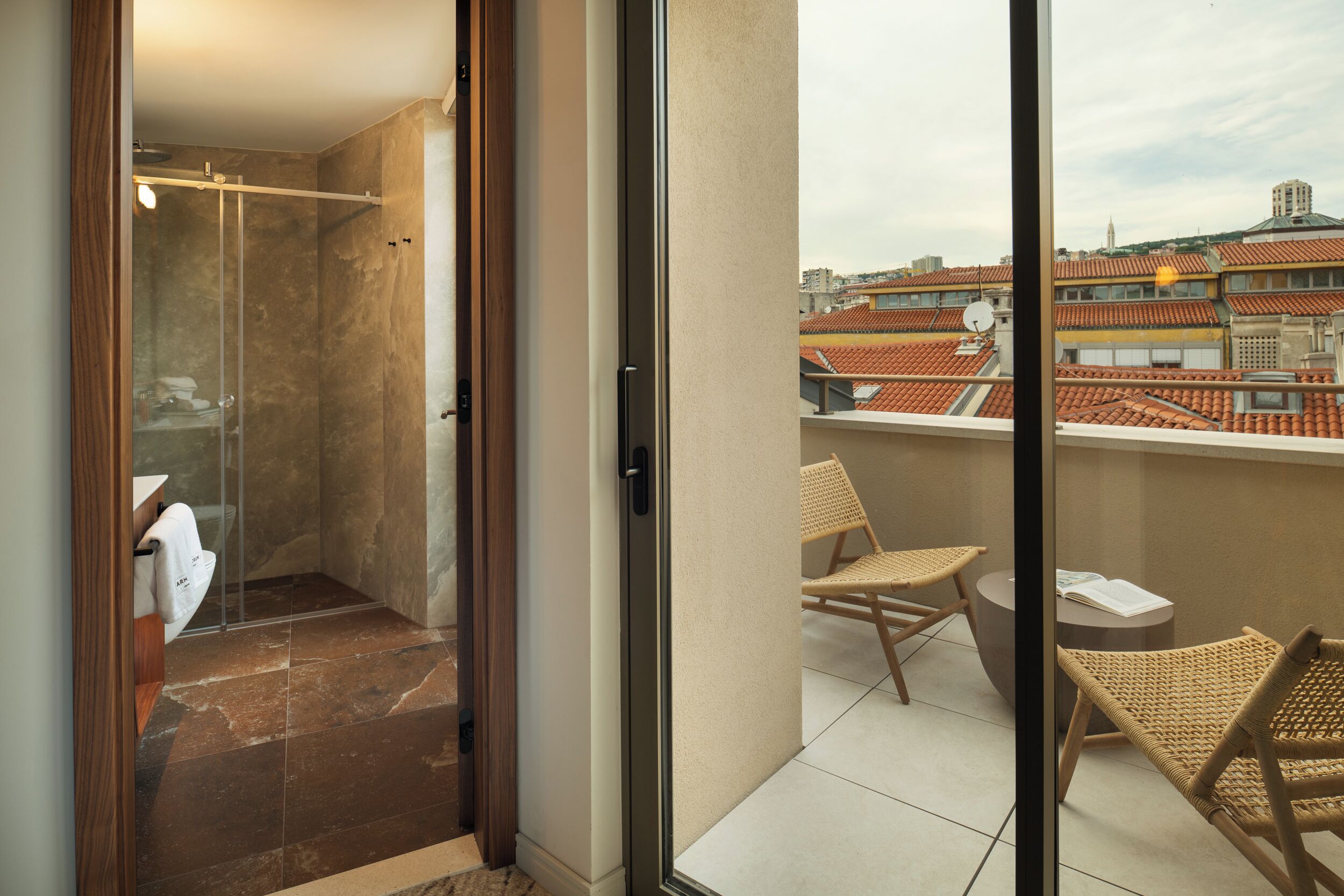 Un baño moderno con cabina de ducha de vidrio, un lavamanos blanco y un perchero para toallas.