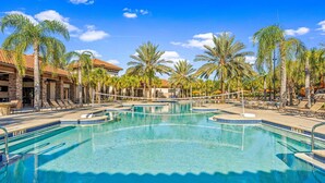 A swimming pool with lounge chairs and palm trees. - 5BR Home with Pool & Resort Amenities Near Disney (Davenport)