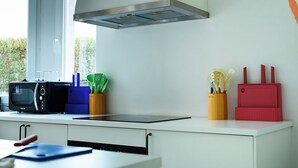 A kitchen with a microwave, toaster, and utensils on the counter. - Cool Cool House (Liège)