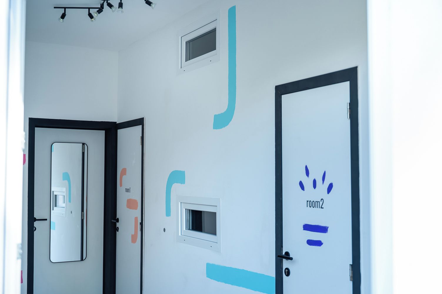 A hallway with doors labeled 'room1' and 'room2', a ceiling light fixture, and a small window.