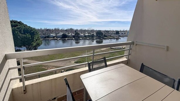 Ein Balkon mit Blick auf einen Fluss und entfernte Gebäude.