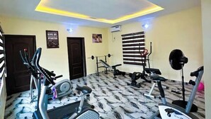 A gym with exercise equipment, a patterned floor, and a ceiling with recessed lighting.