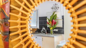 A modern kitchen with a white countertop, a coffee machine, and a vase with flowers. - Quiet 3-suite house with 4 bedrooms - Assured water - Between sea and mountains. (Baie-Mahault)