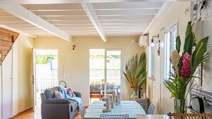 A spacious living area with a dining table, a sofa, and a kitchen area with a sink and countertop. - Quiet 3-suite house with 4 bedrooms - Assured water - Between sea and mountains. (Baie-Mahault)