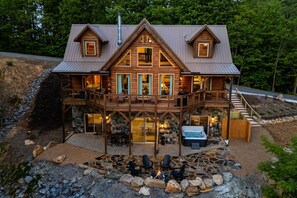 A two-story log cabin with a stone fireplace, outdoor seating, and a hot tub. - Catawba Falls Retreat, Views, Hot Tub & Game Room (Black Mountain)