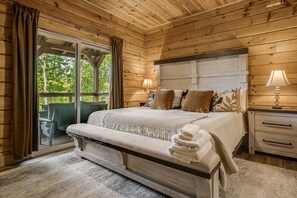 A wooden cabin bedroom with a bed, nightstands, and a bench. - Catawba Falls Retreat, Views, Hot Tub & Game Room (Black Mountain)