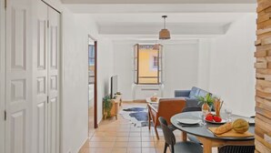 Een moderne eetruimte met een ronde tafel, stoelen en diverse soorten eten.