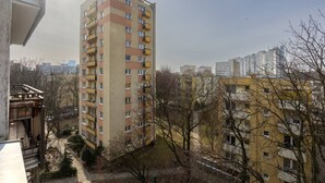A high-rise residential building with multiple balconies, surrounded by other buildings and leafless trees. - Warsaw Wola Studio – Top Location, Bus&Tram nearby (Warszawa)