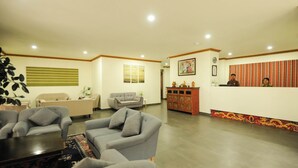 A spacious lobby with a reception desk, sofas, and a decorative cabinet. - Eutsholing Boutique Hotel (Thimphu)