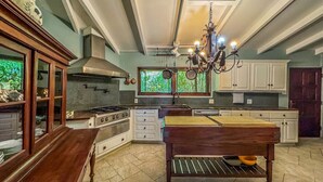 A spacious kitchen with a central island, white cabinetry, and a chandelier. - Panorama Pool House - 3 BR/3BA! (Christiansted)