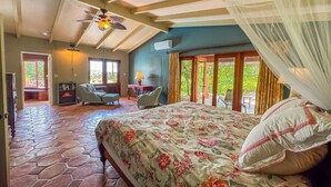 A bedroom with a bed, a ceiling fan, a mosquito net, and a view of the outside. - Panorama Pool House - 3 BR/3BA! (Christiansted)