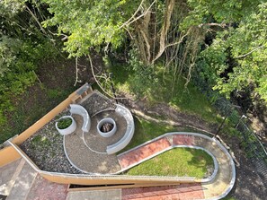 A circular outdoor seating area with a curved pathway, surrounded by dense greenery. - Nativa Park Suites | Exclusive suite with jacuzzi and natural view (Villeta)