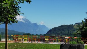 A grassy area with colorful chairs and a mountain backdrop.