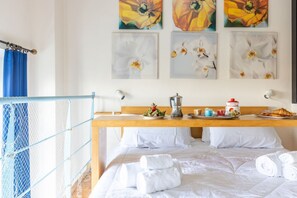 A hotel room with a bed, a breakfast table with a coffee maker, and artwork on the wall. - GuestHost - Charming 50 sqm apartment, located on the 1st floor of a modern building (with lift), for 4 people and equipped with a shared swimming pool (for a fee) and free private parking space.The property is located in Calambrone, with direct access t (Calambrone)