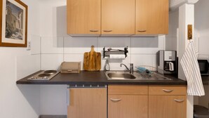 Een moderne keuken met houten kastjes, een ingebouwde kookplaat, een spoelbak en een handdoek.