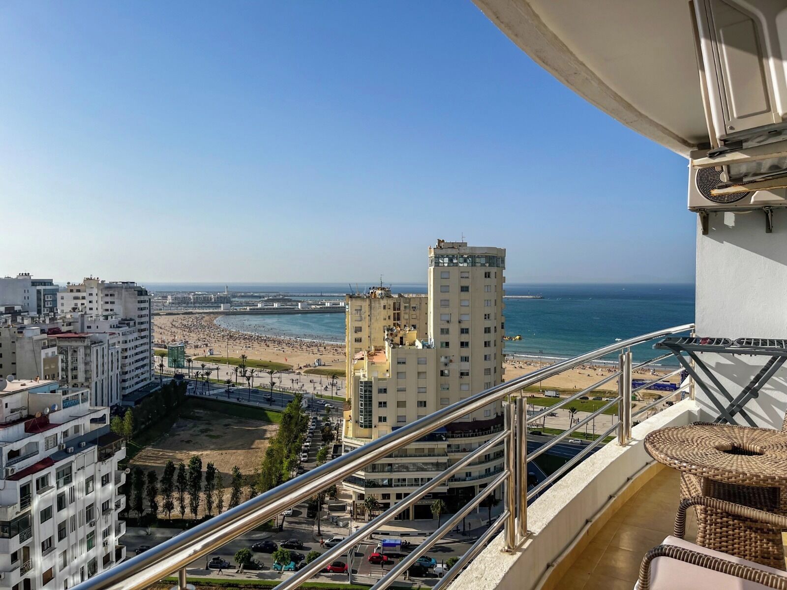 Un balcone con vista su una spiaggia, sullo skyline cittadino e un grattacielo.
