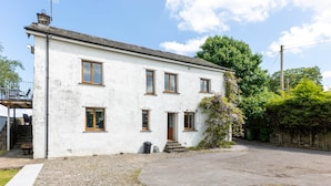A two-story white building with a gravel driveway and a small garden area. - The House at Cherry Tree (Kendal)