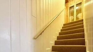 A carpeted staircase with white walls and a wooden handrail. - Trail and Tide-Sleeps 18- Hot tub and Game Room (Island Park)