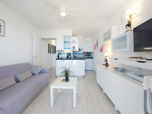 Eine moderne Wohnung mit Wohnzimmer, Küchenzeile und Essbereich.